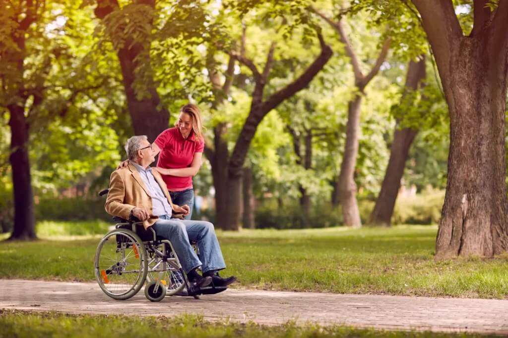 Live-in care aide in Braintree helping a man on wheelchair