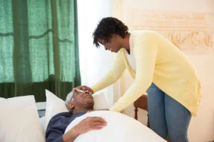 In-home-caregiver examines an elderly patient in bed