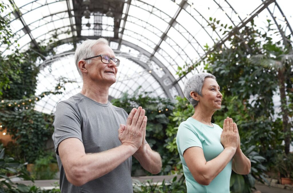 An elderly couple participates in a therapeutic yoga class.