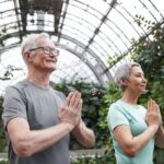 An elderly couple participates in a therapeutic yoga class.