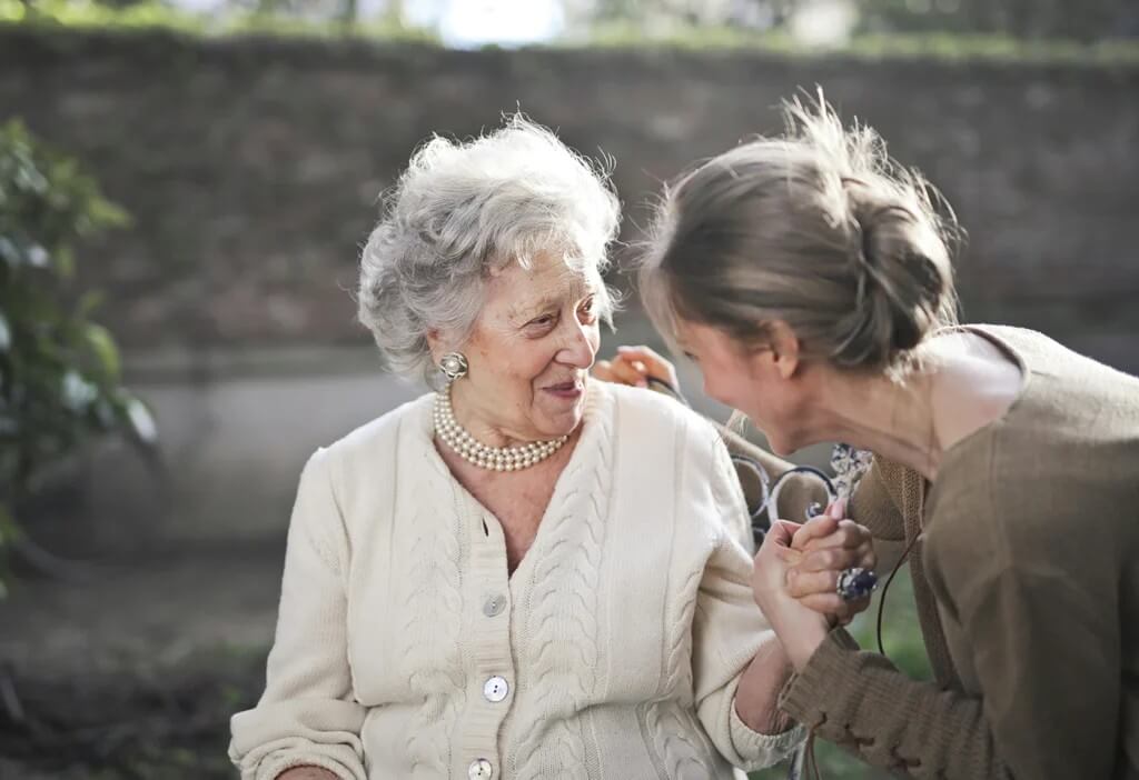 Elderly woman enjoying time outdoors with a senior home caregiver in Hingham, MA