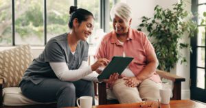 Home Health Care Norwell MA A caregiver and patient looking at a tablet.